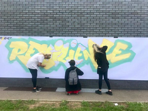 School Pupils Working On Graffiti Art Project With Word Resilience